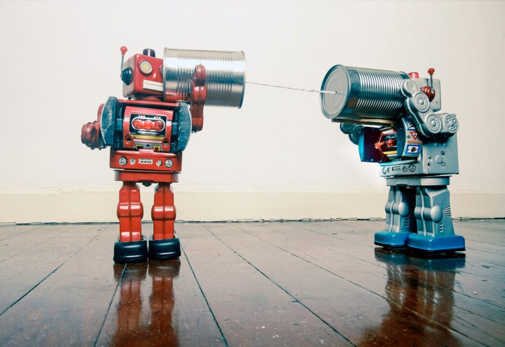 two retro robots talking on tin phones