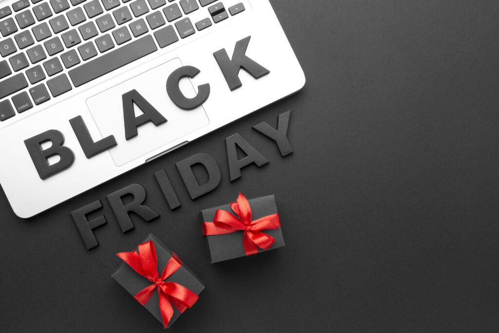 Frase Black Friday em destaque sobre um notebook e com dois presentes ao redor.