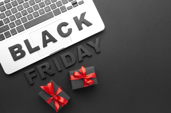 Frase Black Friday em destaque sobre um notebook e com dois presentes ao redor.