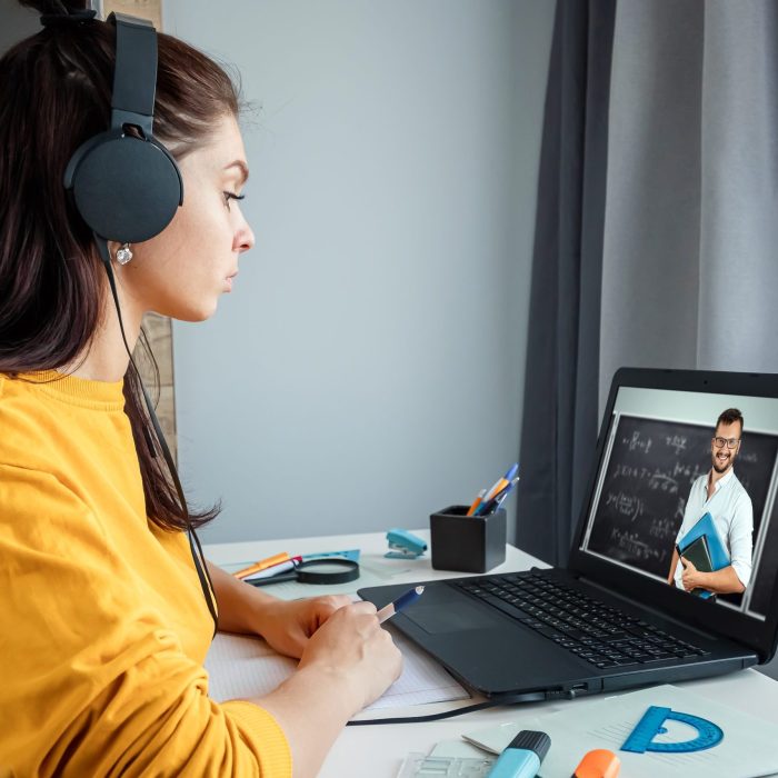 Beautiful girl using laptop studying at home, online education concept, studying science behind a laptop. Watching a webinar, looking for friends on social networks. Modern technologies